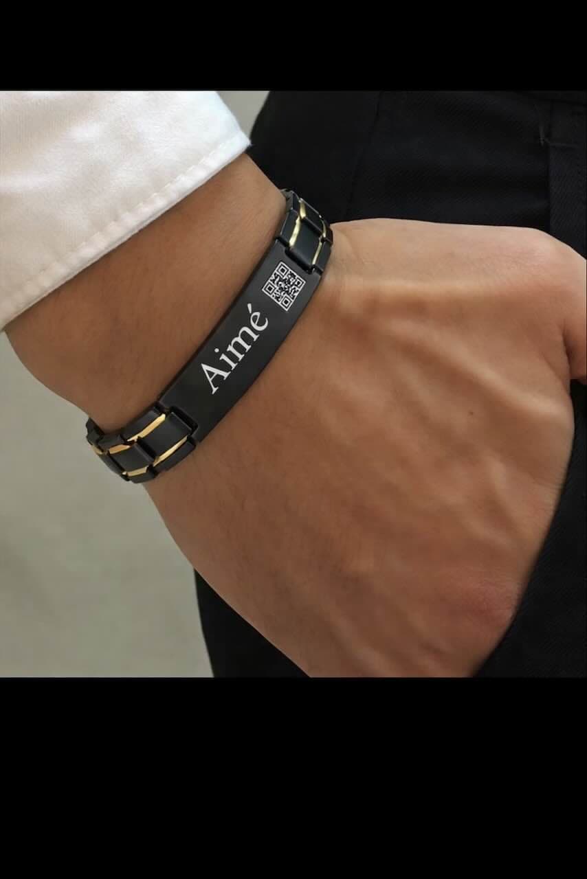 Bracelet moderne en acier inoxydable noir avec plaque personnalisable gravée du prénom de votre choix et un QR code unique. Un bijou élégant et innovant qui allie style et technologie pour garder un souvenir ou un message toujours à portée de main.